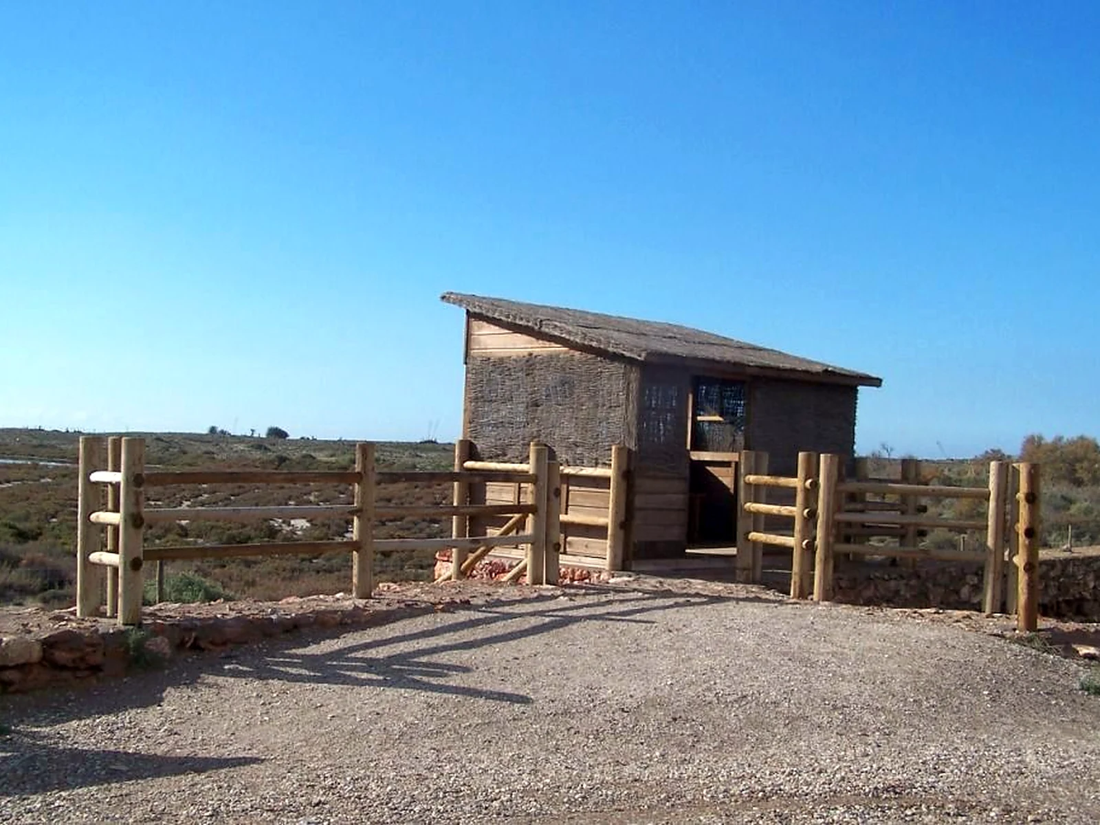 Observatorio de aves de madera frente a unas salinas.